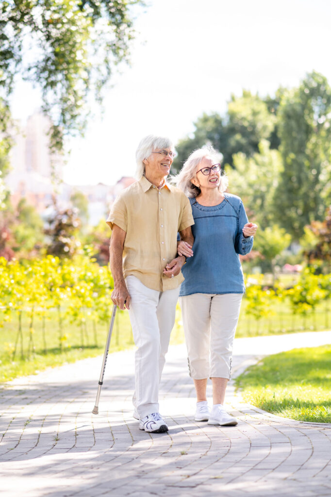 Senior couple with disability walking at the park